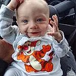 Joue, Sourire, Blanc, Baby & Toddler Clothing, Human Body, Sleeve, Orange, Happy, Baby, Gesture, Finger, Bambin, Cool, Plante, Thumb, Steering Wheel, Enfant, T-shirt, Assis, Baby Products, Personne, Joy