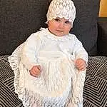 Blanc, Dress, Baby & Toddler Clothing, Textile, Sleeve, One-piece Garment, Embellishment, Bambin, Day Dress, Cap, Comfort, Fashion Design, Pattern, Wool, Assis, Enfant, Woolen, Fashion Accessory, Headpiece, Couch, Personne, Headwear