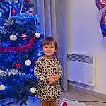 Christmas Tree, Photograph, Sourire, Blanc, Bleu, Light, Purple, Human Body, Christmas Ornament, Plante, Debout, Happy, Fun, Holiday Ornament, Red, Evergreen, Arbre, Ornament, Bambin, Electric Blue, Personne, Joy