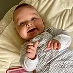Joue, Sourire, Facial Expression, Comfort, Textile, Sleeve, Baby & Toddler Clothing, Gesture, Finger, Baby, Bambin, Happy, Linens, Thumb, Enfant, Pattern, Room, Carmine, Plaid, Baby Products, Personne