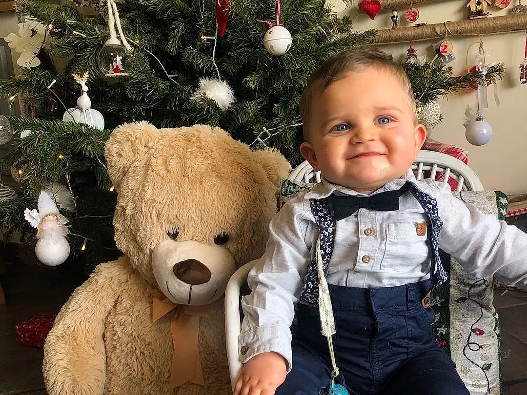 Head, Christmas Tree, Photograph, Sourire, Facial Expression, Blanc, Human Body, Christmas Ornament, Jouets, Happy, Baby & Toddler Clothing, People, Bambin, Baby, Teddy Bear, Noël, Christmas Decoration, Holiday, Event, Personne, Joy