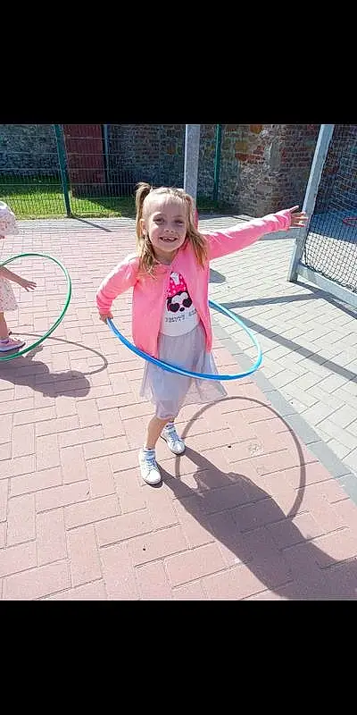 Playing Sports, Hula Hoop, Hoop (rhythmic Gymnastics), Sourire, Shorts, Sports Toy, Entertainment, Jouets, Public Space, Leisure, Bambin, Sneakers, Aire de jeux, Recreation, Swing, Fun, Event, Enfant, City, Herbe, Personne, Joy