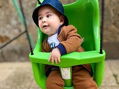 Visage, Vêtements d’extérieur, Yeux, Green, Sleeve, Baby & Toddler Clothing, Baby, Herbe, Public Space, Bambin, Leisure, Sneakers, Recreation, Fun, Swing, Happy, People In Nature, Assis, City, Comfort, Personne, Headwear