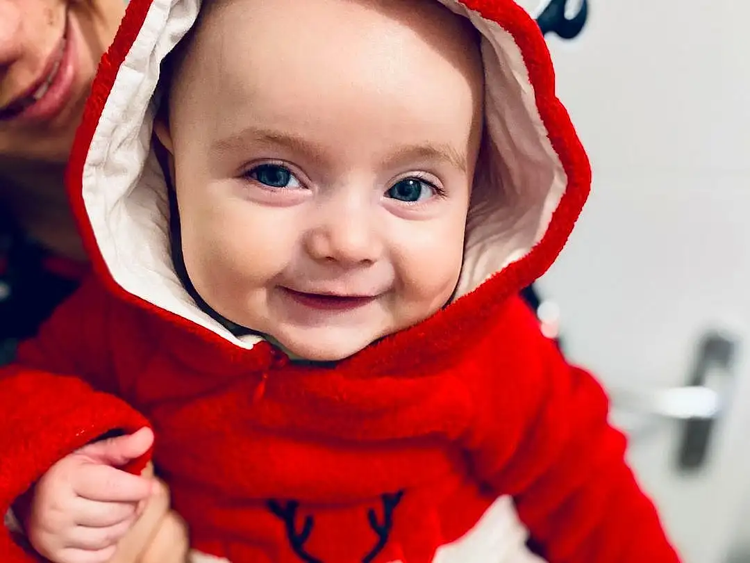 Joue, Peau, Head, Lip, Sourire, Yeux, Blanc, Human Body, Sleeve, Happy, Baby & Toddler Clothing, Cap, Baby, Bambin, Red, Costume Hat, Santa Claus, Fun, Event, Fictional Character, Personne, Joy