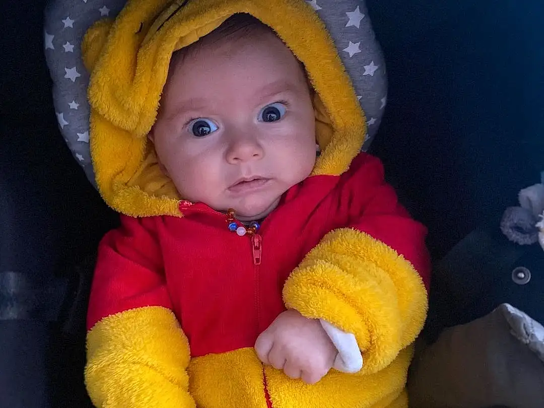 Nez, Joue, Peau, Head, Chin, Yeux, Eyebrow, Facial Expression, Mouth, Baby & Toddler Clothing, Human Body, Baby, Sleeve, Iris, Orange, Yellow, Jacket, Bambin, Comfort, Baby Products, Personne, Headwear