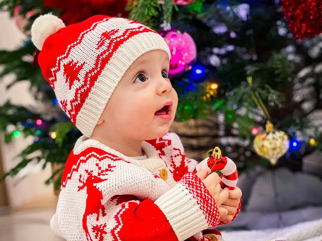 VÃªtements dâ€™extÃ©rieur, Facial Expression, Christmas Tree, Baby & Toddler Clothing, Sleeve, Chapi Chapo, Happy, Christmas Decoration, Bambin, Costume Hat, Christmas Ornament, Baby, Event, NoÃ«l, Enfant, Holiday, Hiver, Christmas Eve, Pattern, Cap, Personne, Headwear