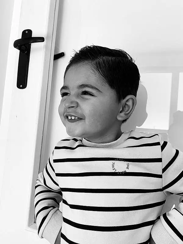 Chin, Shoulder, Sourire, Sleeve, Debout, Happy, Gesture, Black-and-white, Flash Photography, Style, Eyelash, Bambin, Monochrome, Elbow, Noir & Blanc, Baby & Toddler Clothing, T-shirt, Enfant, Baby, Room, Personne