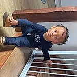 Bois, Sourire, Sleeve, Flash Photography, Bambin, Hardwood, Happy, T-shirt, Baby & Toddler Clothing, Denim, Enfant, Chapi Chapo, Fun, Elbow, Assis, Wood Stain, Thigh, Wood Flooring, Foot, Personne