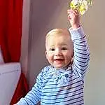 Joint, Sourire, Sleeve, Debout, Lighting, Yellow, Gesture, Finger, Baby & Toddler Clothing, Happy, Bambin, T-shirt, Baby, Fun, People, Enfant, Room, Curtain, Table, Personne, Joy