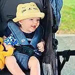 Peau, Sourire, Photograph, Facial Expression, Chapi Chapo, Black, Baby Carriage, Baby & Toddler Clothing, Sun Hat, Baby, Bambin, People, Cap, Street Fashion, Enfant, Happy, Fun, Electric Blue, Personne, Headwear