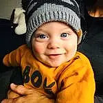 Nez, Joue, Peau, Lip, Sourire, Eyebrow, Yeux, Cap, Flash Photography, Sleeve, Gesture, Happy, Finger, Bambin, Cool, Baby, Thumb, Baby & Toddler Clothing, Enfant, Knit Cap, Personne, Joy, Headwear