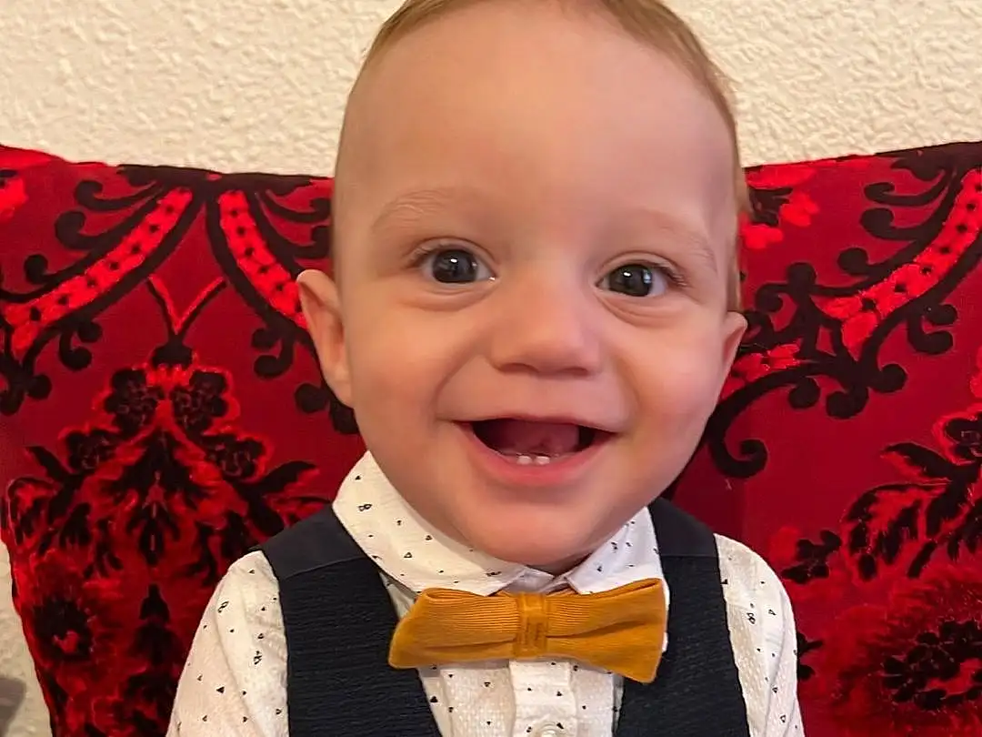 Hair, Visage, Joue, Sourire, Peau, Head, Chin, Coiffure, Yeux, Neck, Human Body, Bow Tie, Sleeve, Flash Photography, Baby & Toddler Clothing, Happy, Baby, Iris, Bambin, Red, Personne, Joy