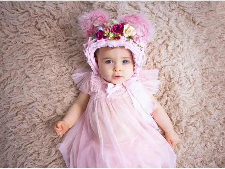Clothing, Dress, Baby & Toddler Clothing, Sleeve, Rose, Happy, Embellishment, Bambin, Petal, Flash Photography, Baby, Day Dress, Headpiece, Headband, Magenta, Pattern, Enfant, Costume Hat, Fashion Accessory, Linens, Personne, Headwear