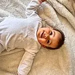 Peau, Sourire, Facial Expression, Comfort, Sleeve, Gesture, Happy, Baby & Toddler Clothing, Bambin, Linens, Collar, Enfant, Bedding, Portrait Photography, Laugh, Baby Sleeping, Sleep, Personne