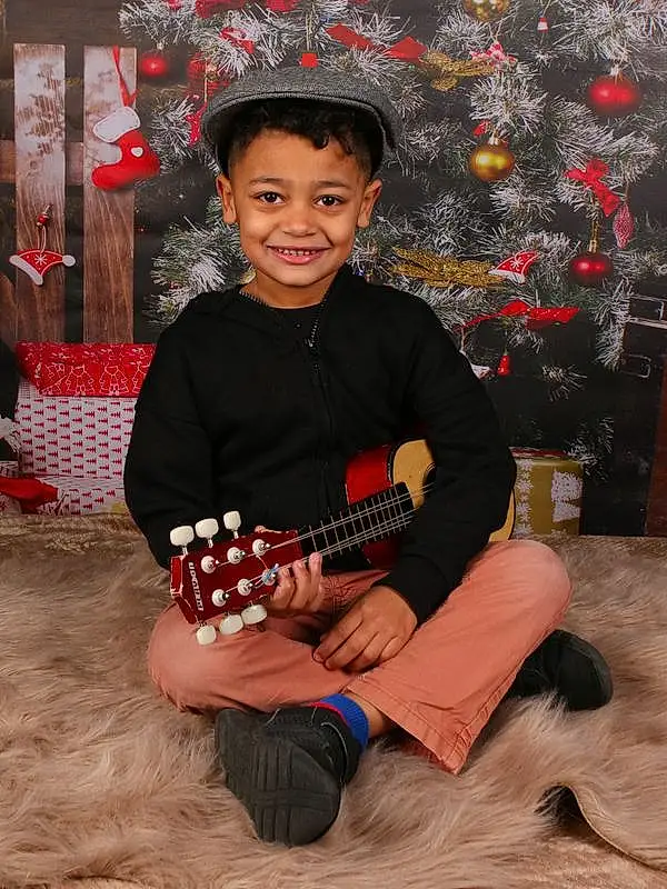 Sourire, Happy, Christmas Tree, Flash Photography, Fun, Lap, Holiday, Event, Assis, Enfant, Bambin, Wheel, Musical Instrument, Pattern, Noël, Ornament, Jouets, Portrait Photography, Room, Personne, Joy