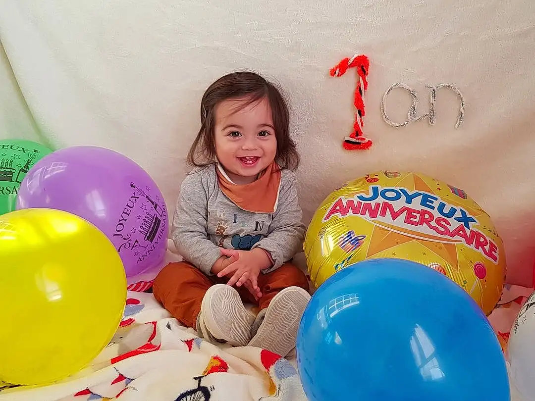 Sourire, Facial Expression, Balloon, Happy, Fun, Party Supply, Jouets, Bambin, People, Leisure, Enfant, Beauty, Event, Recreation, Party, Play, Magenta, Room, T-shirt, Circle, Personne, Joy